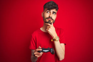 shutterstock 1499787998 300x200 - Young,Gamer,Man,With,Tattoo,Playing,Video,Game,Standing,Over